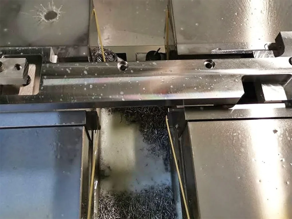 銑床加工：機台上正在加工的長條工件與切屑